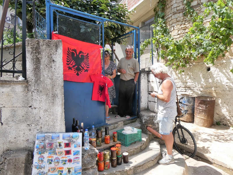 Albanese man en vrouw verkopen op het trappetje voor hun huis koelkastmagneetjes en huisgemaakte producten aan Wim.