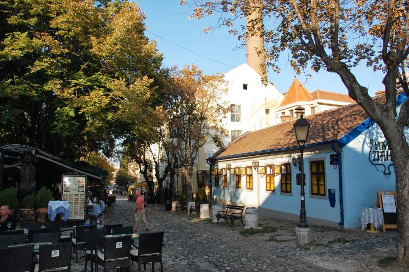 Terrasje, keitjesweg en kleine gebouwen in de wijk Skadarija in Belgrado