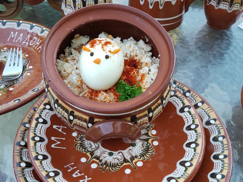 Sireni po Shopski - stoofschotel met ei met gezichtje, geserveerd in traditioneel Bulgaars servies