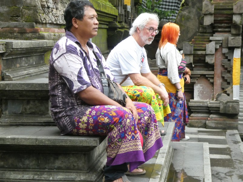 Ketut en Wim bekijken de rituele reiniging in de Pura Tirta Empul  vanaf een trapje