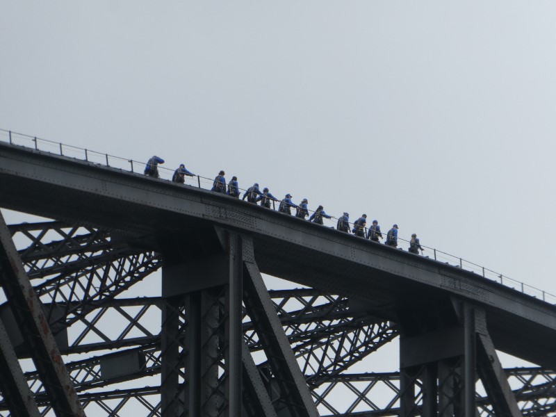 Groep mensen loopt bovenover de Harbour Bridge