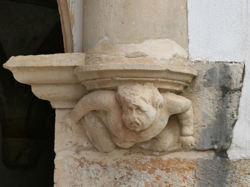 Gebeeldhouwd kind dat pilaar op z'n rug draagt in het Convento de Cristo in Tomar