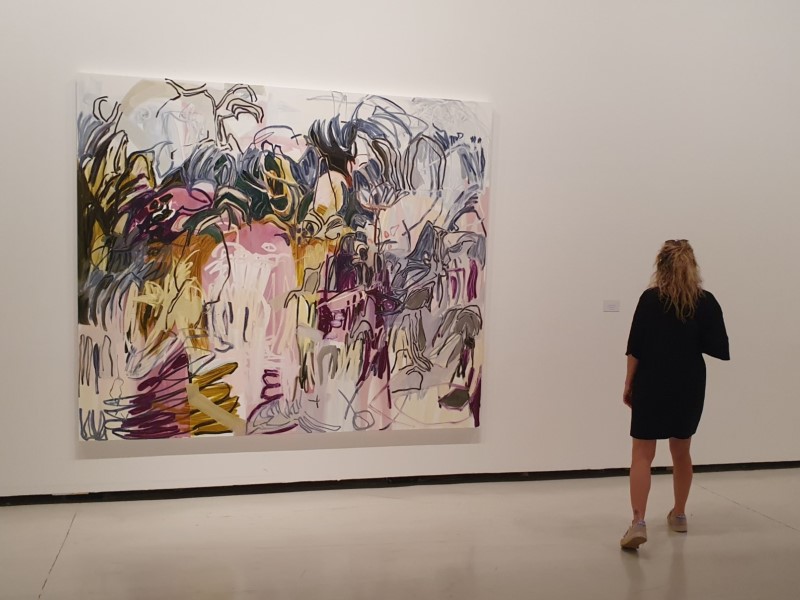 Vrouw voor groot abstract schilderij in het CAC-museum in Málaga