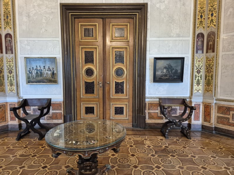 Kamer met salontafel, 2 zetels en versierde deur en vloer in Schloss Schwerin